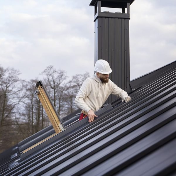 Ouvrier en intervention sur une toiture en zinc à joint debout, travaux de couverture et zinguerie